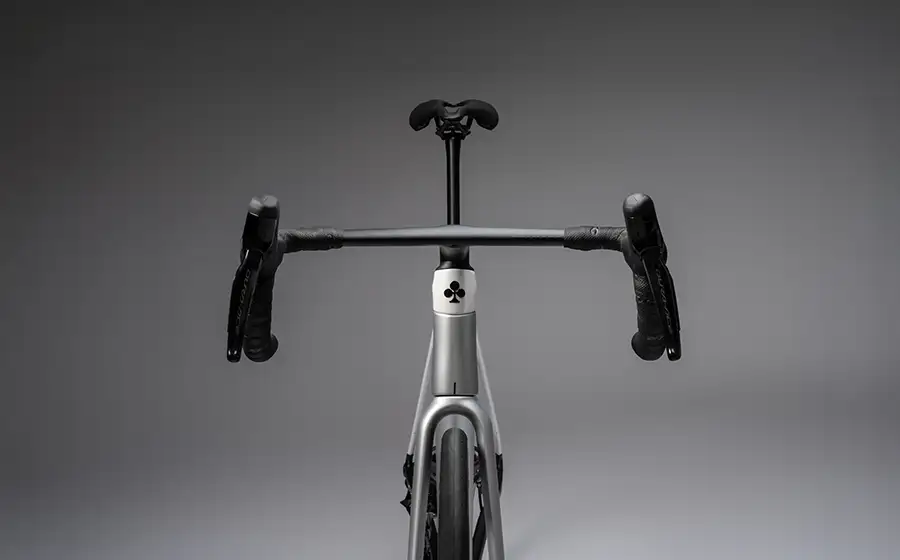 Detajl krmila in okvirja cestnega kolesa Colnago C72 na sivem ozadju